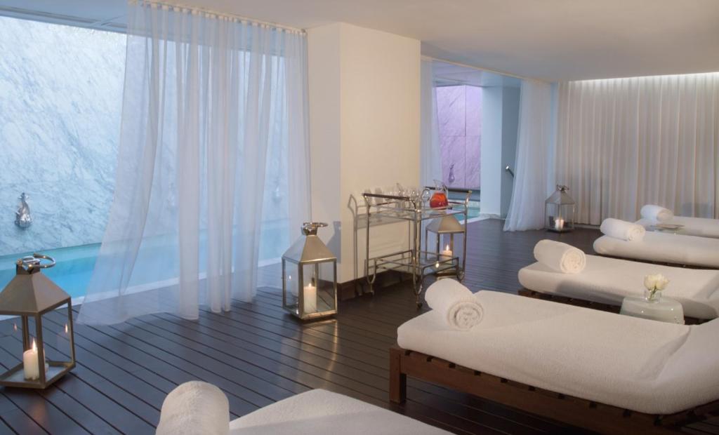 埃斯特角城Yoo Punta Del Este的客厅配有白色家具和游泳池