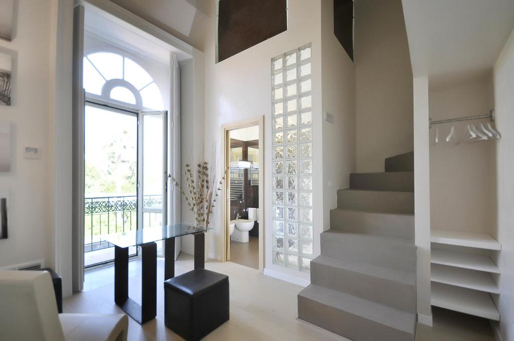 埃尔科拉诺巴蒂斯塔别墅酒店 的走廊设有楼梯、桌子和窗户