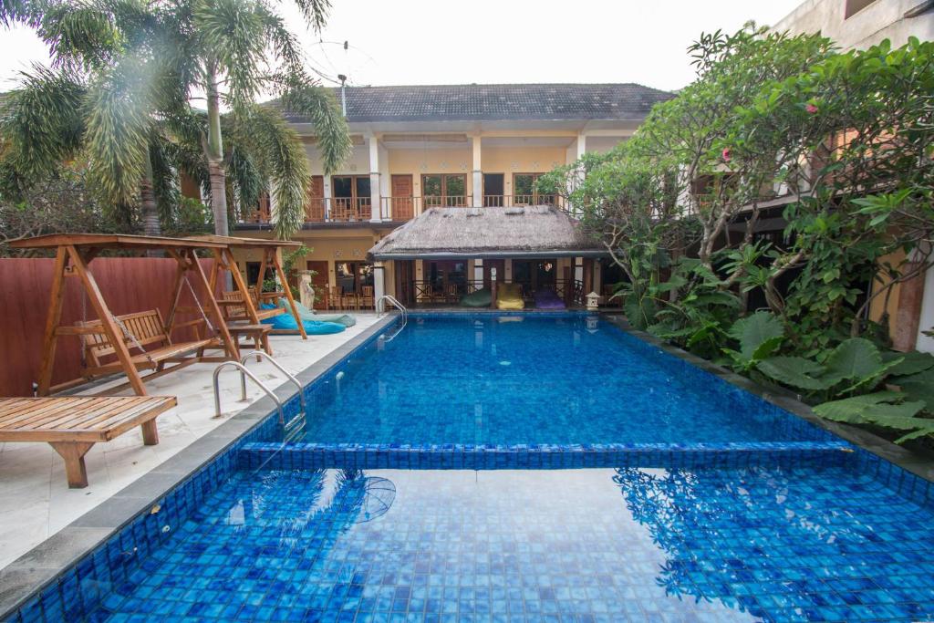 圣吉吉Central Inn Senggigi的大楼前的大型蓝色游泳池
