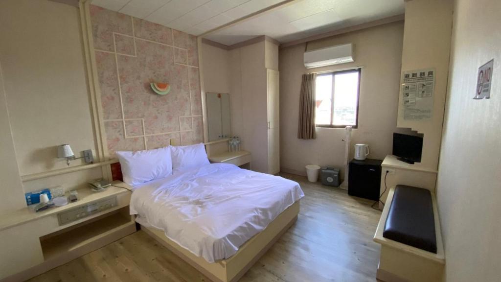 北港镇日日 Meworld的卧室配有白色的床和窗户。