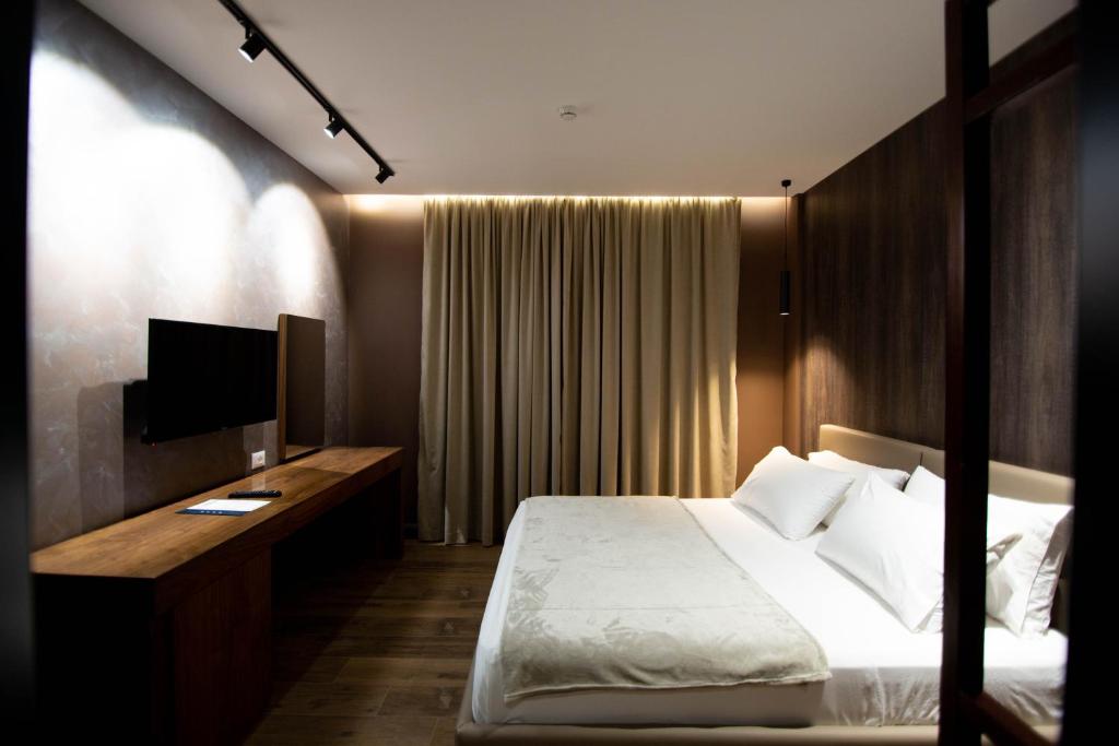 戈里察Mergan Hotel的一间卧室配有一张床和一张书桌及电视
