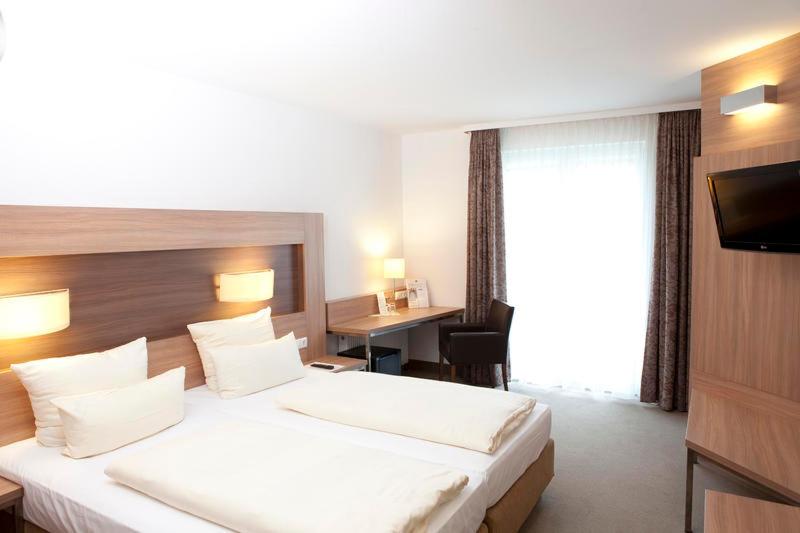 比勒费尔德sleep in - Bielefeld Boardinghouse的酒店客房设有一张大床和一张书桌。