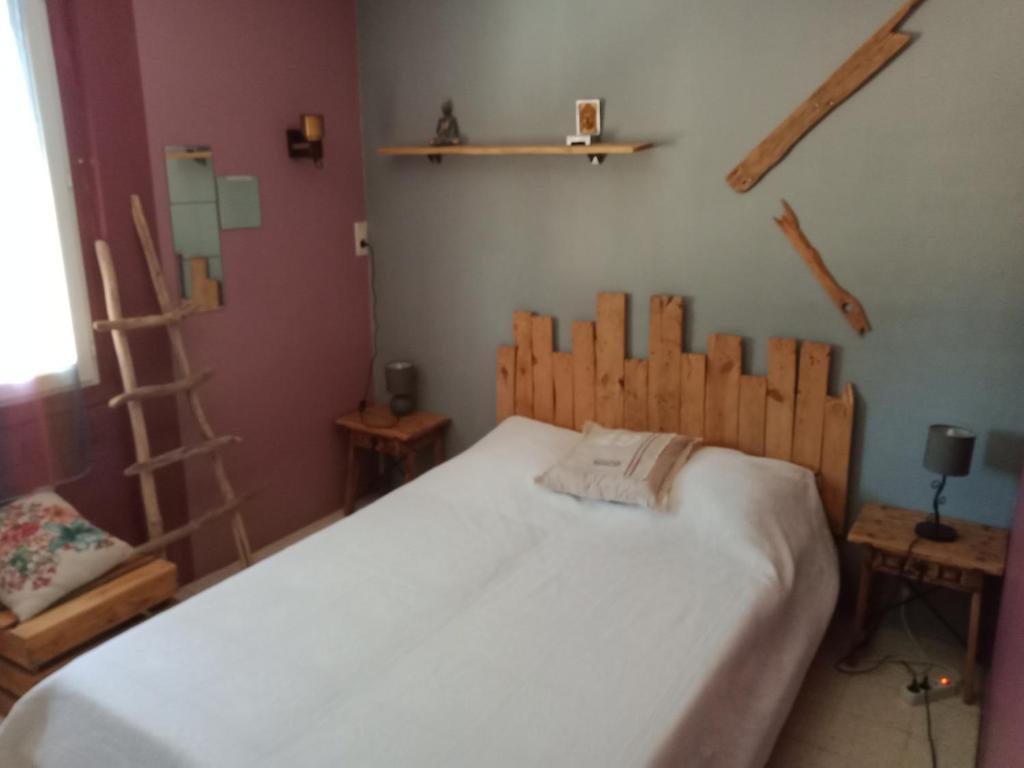 皮耶尔拉特Chambre chez l'habitant的一间卧室配有一张带木制床头板的床