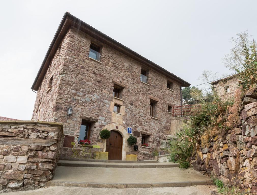 Montenegro de CamerosPosada Real La Almazuela的一座大型石头建筑,设有棕色的门和楼梯