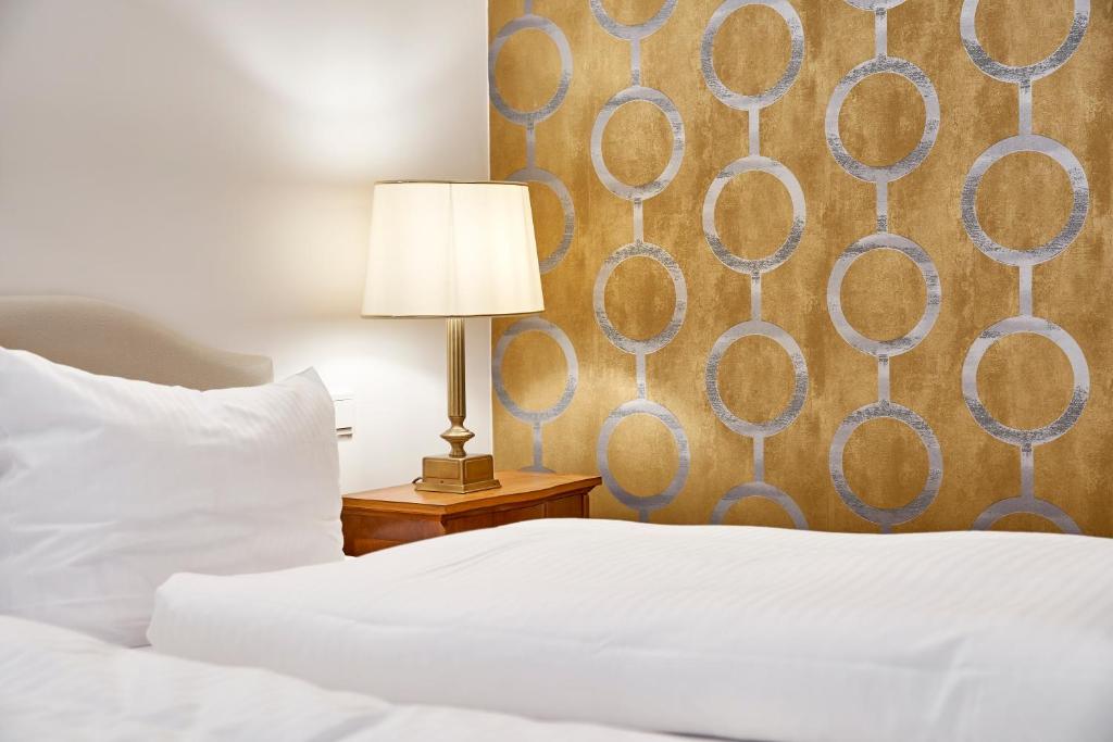 慕尼黑卡拉夫特酒店的一间卧室配有一张床和一张桌子上的台灯