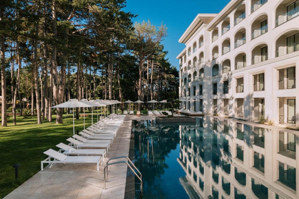 圣君士坦丁和海伦那Ensana Aquahouse的酒店游泳池旁设有椅子和遮阳伞