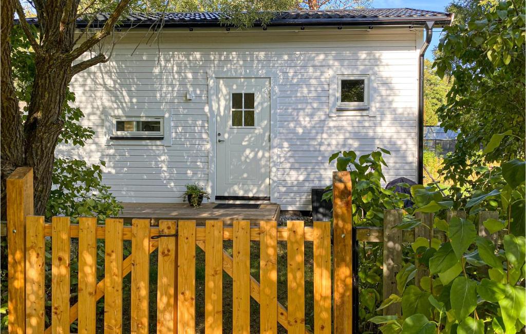 GnisvärdBeautiful Home In Gotlands Tofta With Kitchen的前面有木栅栏的白色房子