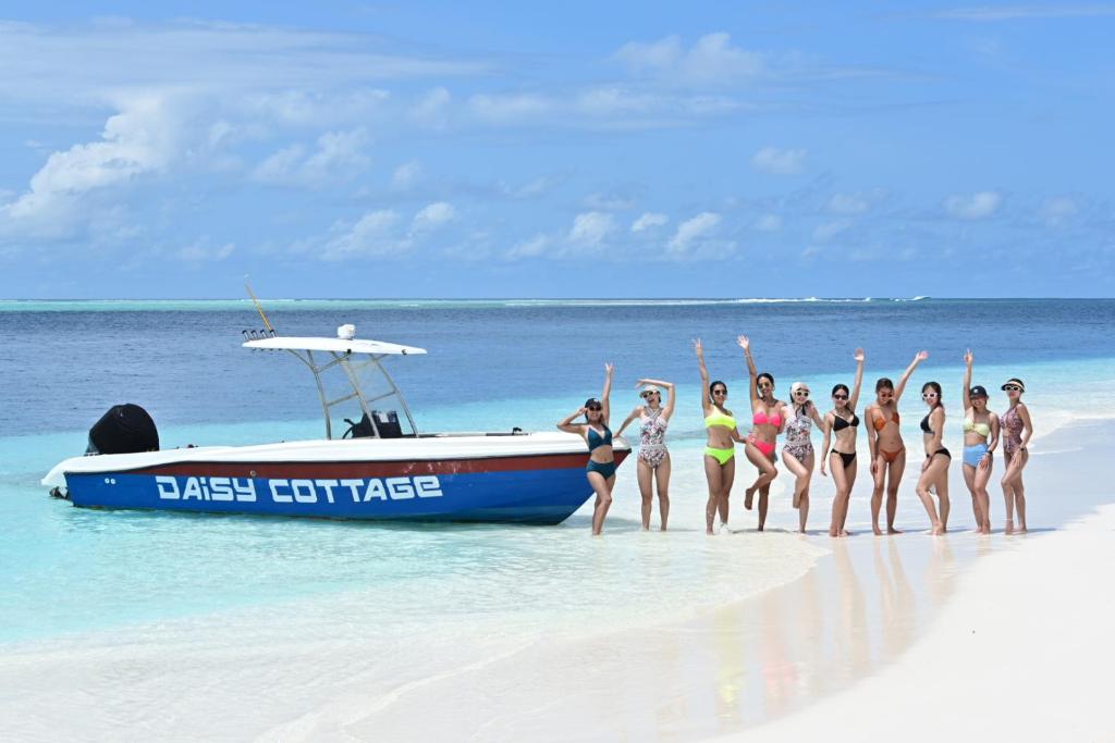 丹格迪Daisy Cottage Dhangethi的一群站在海滩上的妇女,在船上