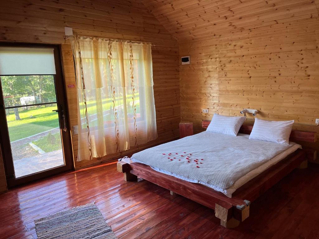 Podu lui NeagComplex turistic Traisteni din Valea Doftanei的木制客房的一间卧室配有一张床,设有窗户