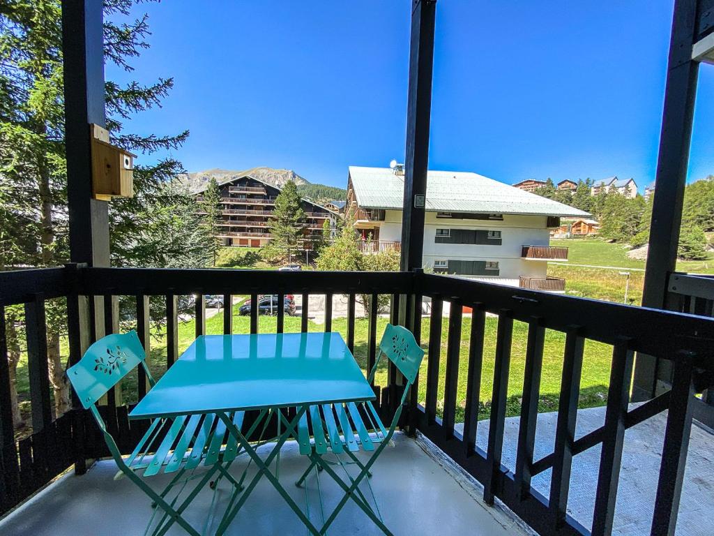 圣埃蒂安德蒂内埃Studio balcon vue Alpes pistes de ski à 5 min的阳台配有一张蓝色的桌子和两把椅子