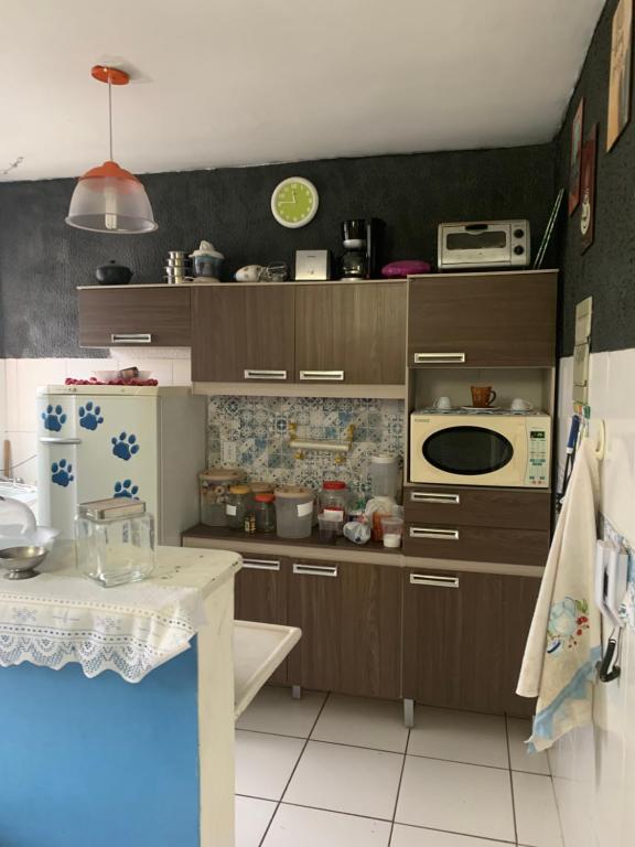 贝廷Residencial bela vista的厨房配有棕色橱柜和白色瓷砖地板。