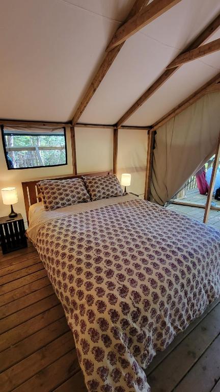 DwightDwight Riverside Inn的帐篷内一间卧室,配有一张床