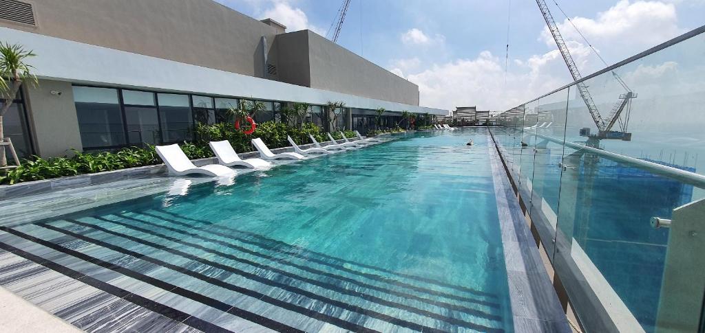 头顿The Sóng-Căn hộ du lịch 5 sao Vũng Tàu的一座带白色椅子的游泳池和一座建筑
