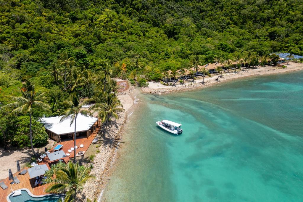 长岛Elysian Luxury Eco Island Retreat的海滩旁的水中小船