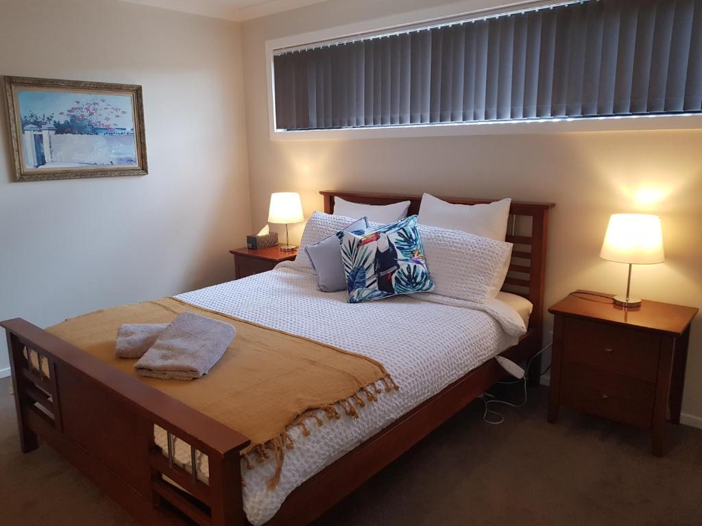 托基Torquay Homestay Guesthouse的一间卧室配有一张大床、枕头和两盏灯。