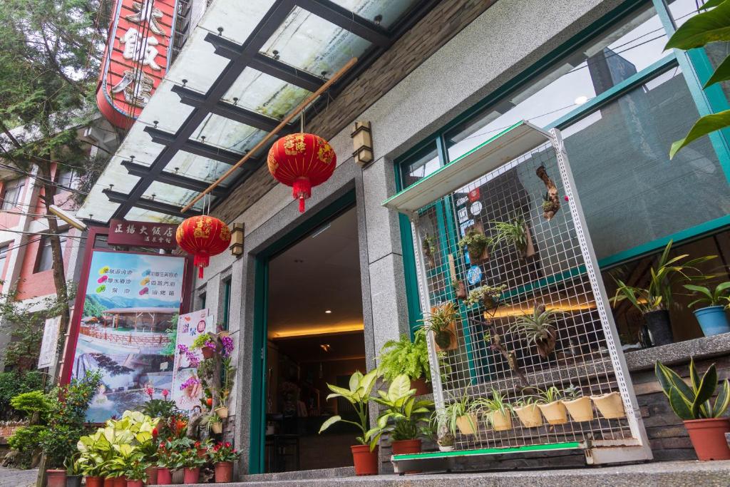 仁爱乡正扬温泉渡假饭店 的商店前方有红色灯笼和植物