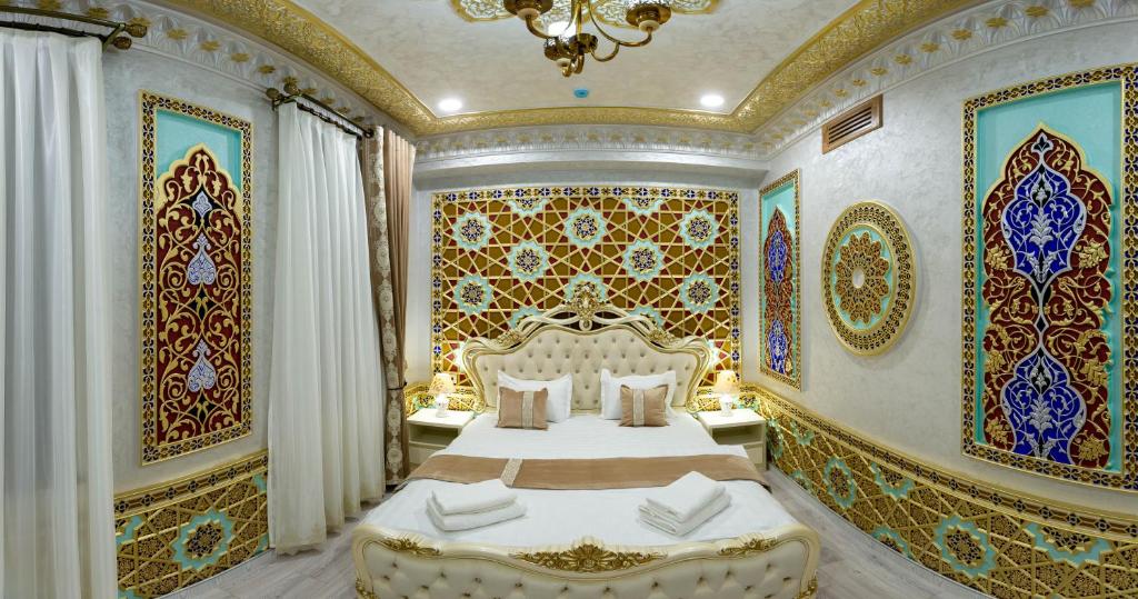 布哈拉Asian Plaza的卧室设有一张大床,卧室拥有色彩缤纷的墙壁