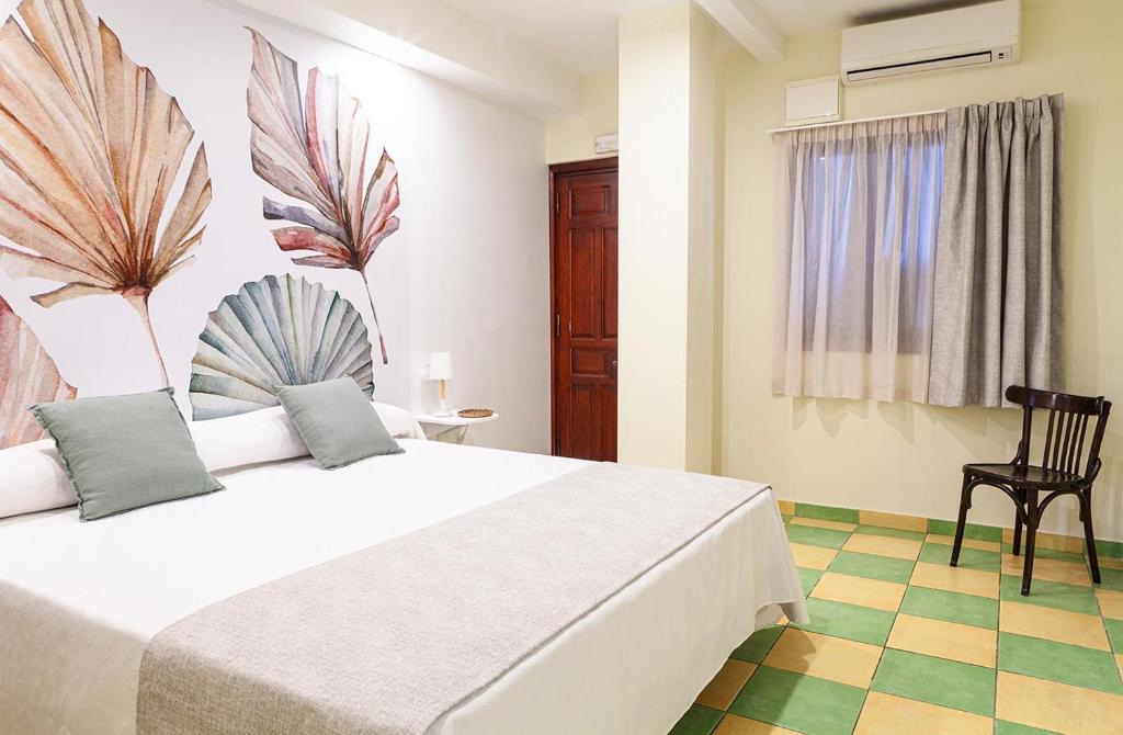 波洛普Hostal León Dormido的卧室配有一张白色大床和一把椅子