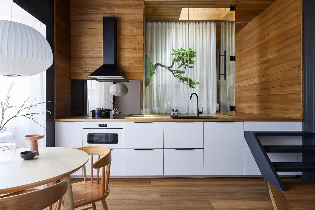 悉尼The Ryokan - Zen的厨房配有白色橱柜和桌子
