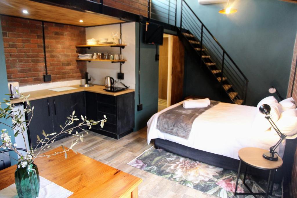 布隆方丹Nini's guest units的一间卧室设有一张床,楼梯位于卧室内