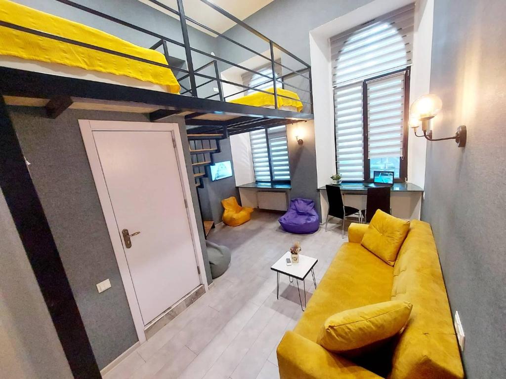 第比利斯The Passenger Rooms的客厅设有黄色的沙发和双层床。