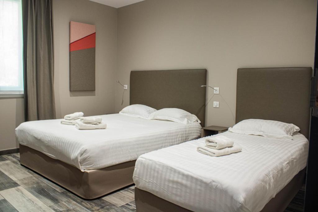 Porcieu-Amblagnieu索思的两张位于酒店客房的床,配有毛巾