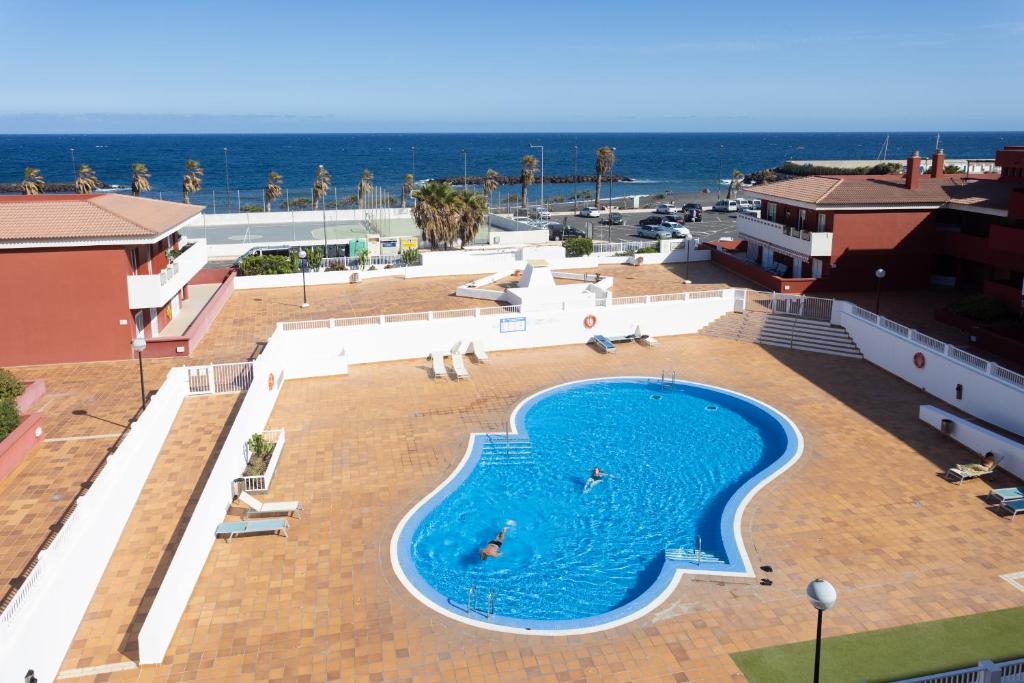 圭马尔港Home2Book Sea Front Duplex Terrace Pool的一个大型的游泳池,背景是大海