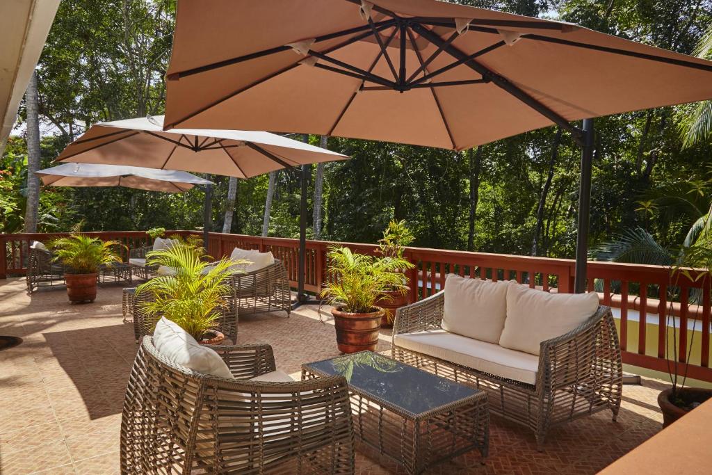 孔塔多拉孔塔多拉岛酒店的庭院配有椅子和桌子及遮阳伞