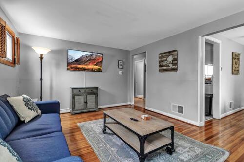 布法罗Gorgeous 2 Bedroom Lower Apartment with Free Driveway Parking in North Buffalo的客厅配有蓝色的沙发和桌子