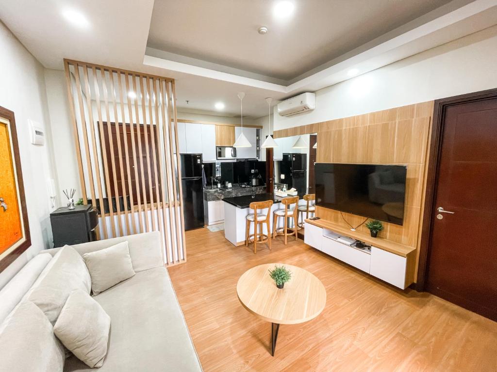 雅加达2 Bedrooms Permata Hijau Suites Apartment的客厅配有沙发和桌子