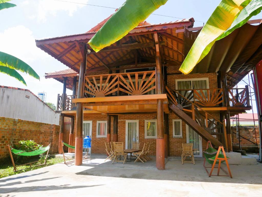 Kon RơbangXô Xôn Homestay的房屋设有木屋顶、桌椅