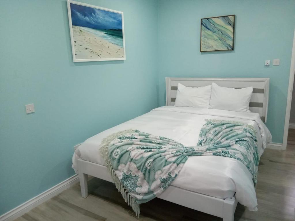 ChocJemmRose Suites的卧室配有一张白色的床,床上有毯子