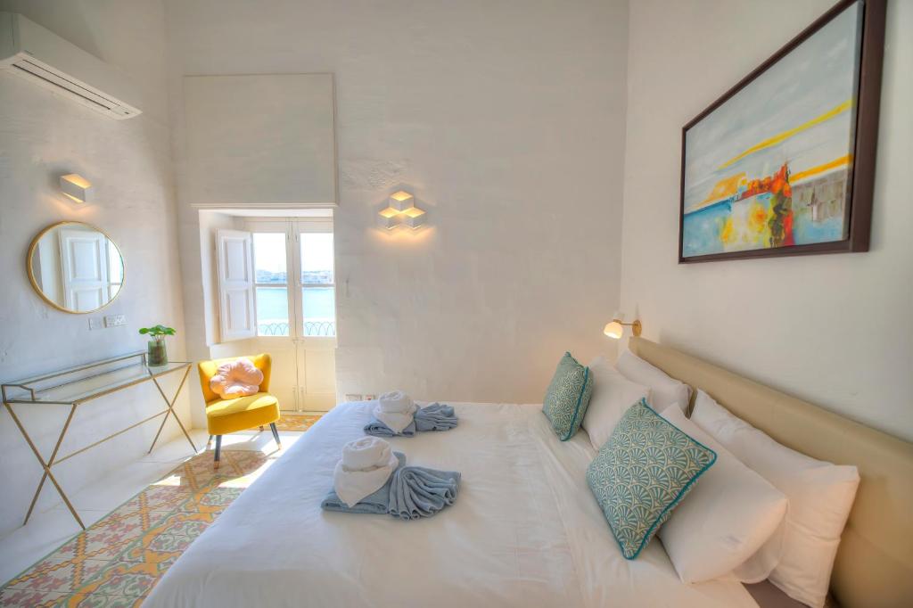 瓦莱塔Spacious maisonette with spectacular views IBRI1-1的卧室配有白色床和毛巾