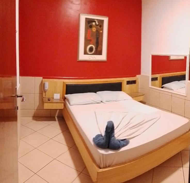 圣保罗Hotel Smart Inn的红色墙壁的房间里一张床位