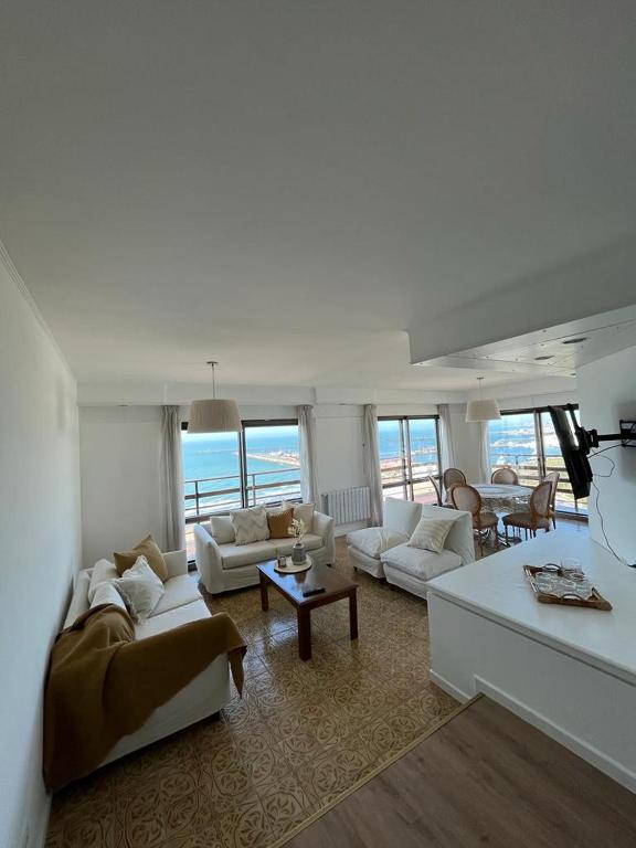 马德普拉塔Los Petos - Playa Grande的客厅配有白色家具,享有海景。