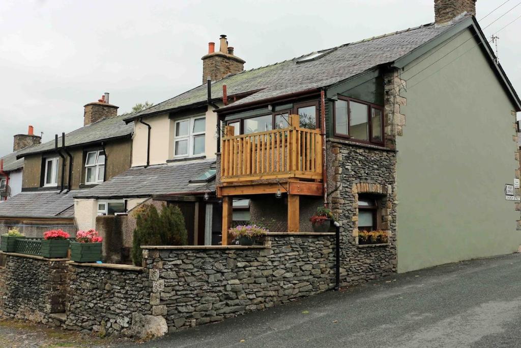 蒂贝Cumbrian cottage, sleeps 6, in convenient location的石头房子的侧面有甲板