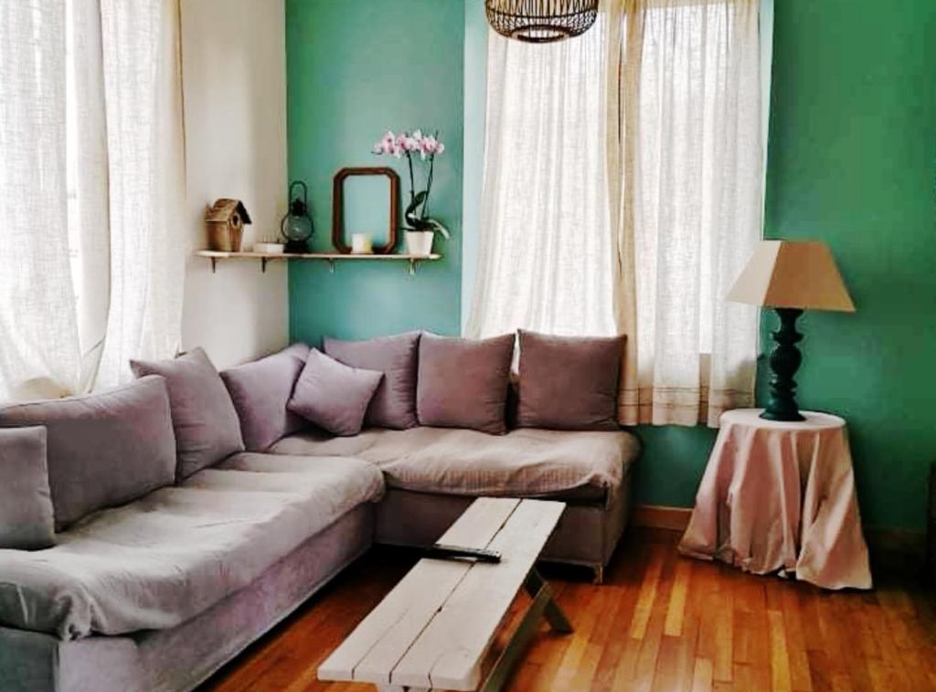 Gite mes pt'tis lits maison chaleureuse 4 chambres的带沙发和绿色墙壁的客厅