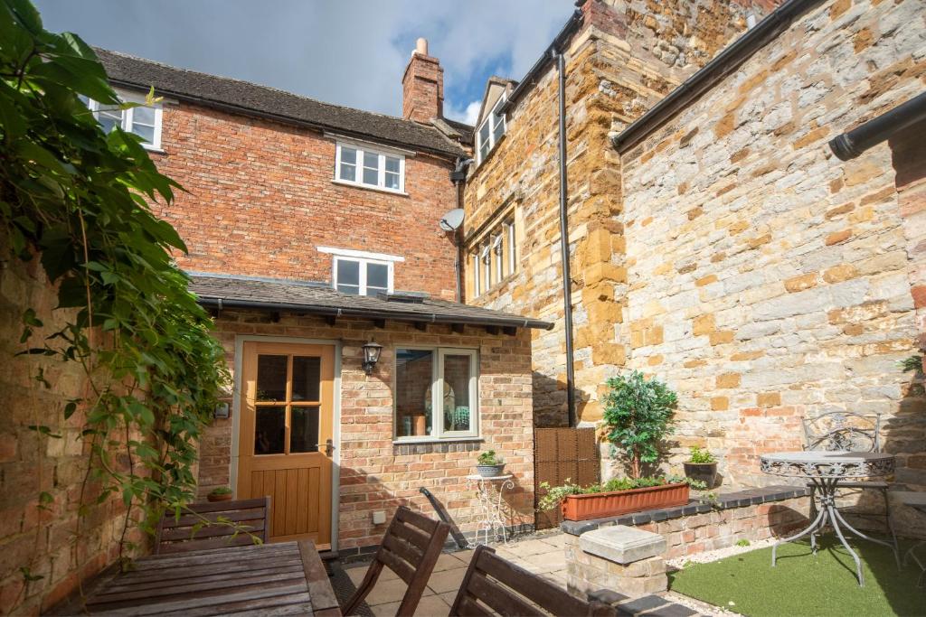 斯托尔河畔希普斯顿Cotswolds period townhouse near Stratford-upon-Avon, central location short walk to pubs, restaurants and shops的一座带木门的老砖房的庭院