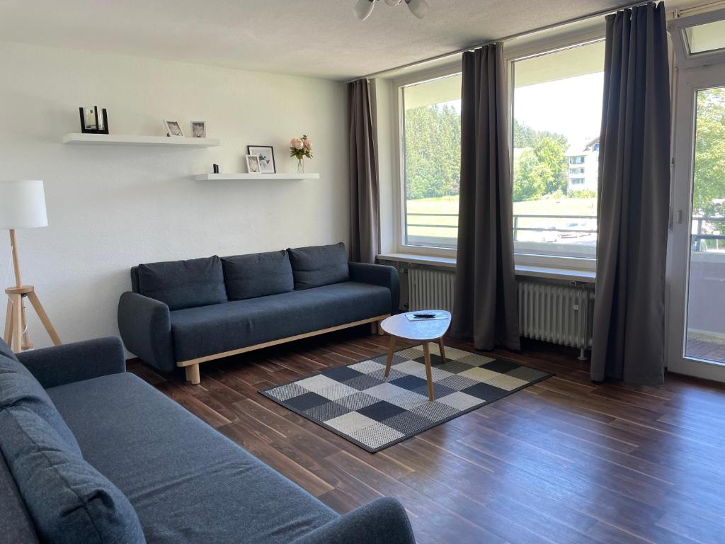 福森Ferienwohnung Bergblick的客厅配有蓝色的沙发和桌子