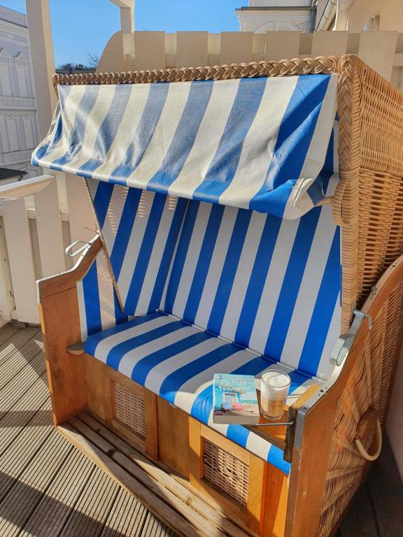 奥斯赛拜-塞林DAS APPARTEMENT INSELLIEBE RÜGEN inkl Sauna und 3h täglich Eintritt AHOI Schwimmbad的一张柳条椅,坐在门廊上,桌子