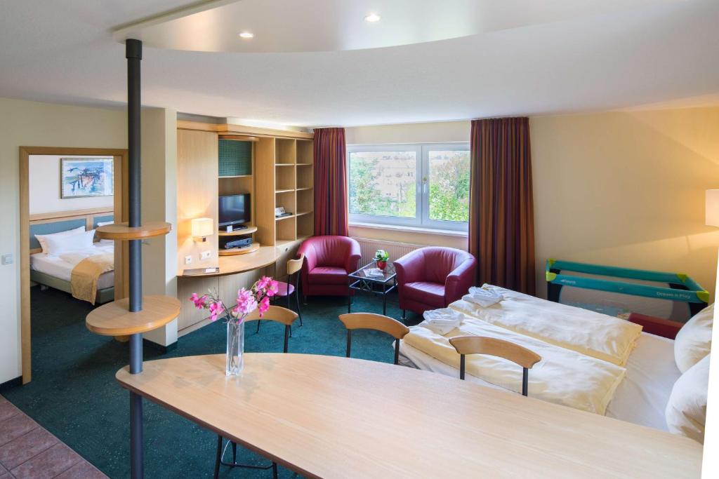 莱比锡莱比锡套房酒店的酒店客房带一张床、一张桌子和椅子