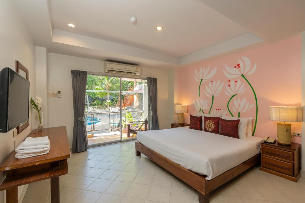 芭堤雅市中心Bella Villa Pattaya 3rd Road的一间卧室设有一张床、一台电视和一个窗口。