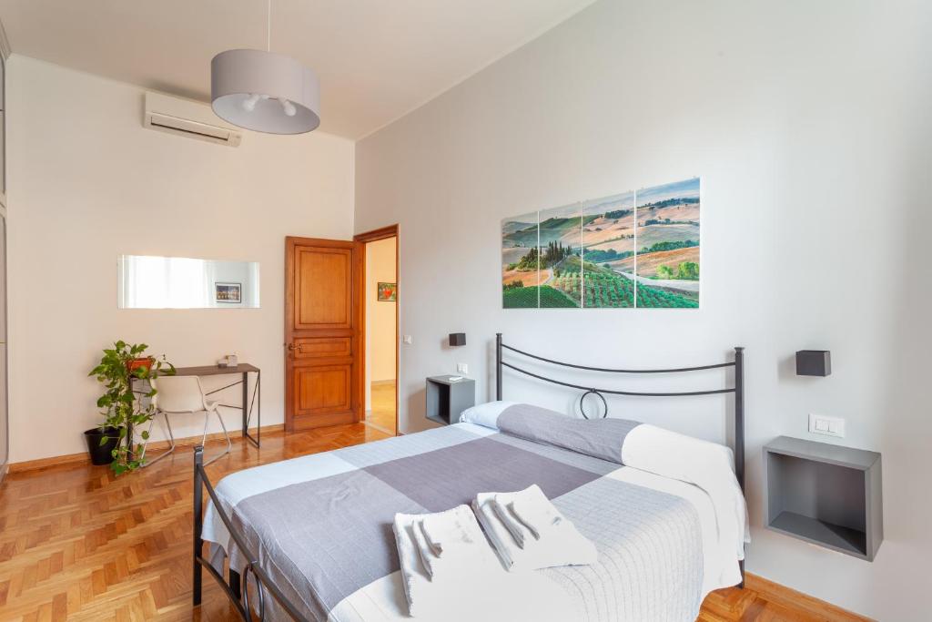 罗马Il Melograno Holiday House的一间卧室配有一张床、一张书桌和一台电视。