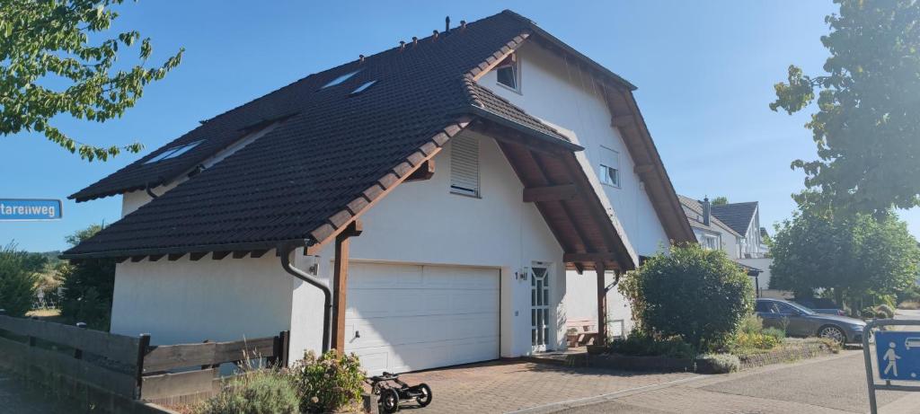 BischweierFerienwohnung zwischen Rhein und Schwarzwald的白色的房子,有 ⁇ 帽屋顶和车库