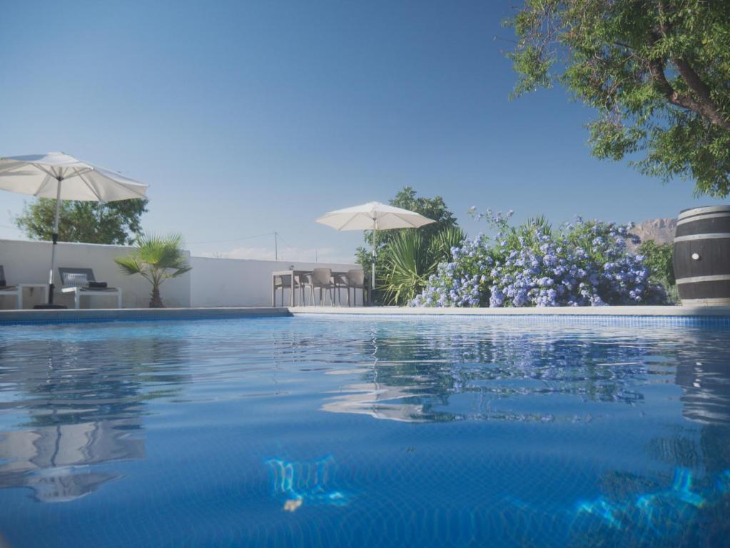 贝莱斯-鲁维奥Boutique Bed & Breakfast Casa Paco - adults only的一个带蓝色水和遮阳伞的游泳池