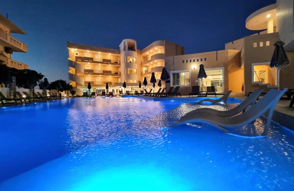 基萨莫斯Sunny Bay Hotel的夜间在酒店前的游泳池