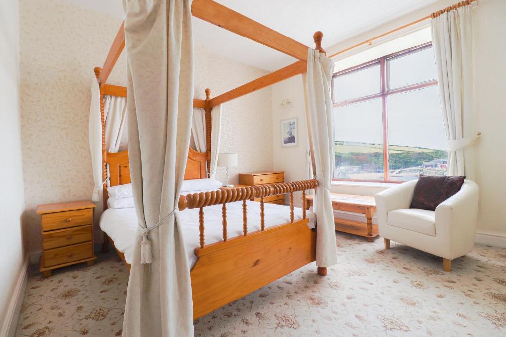 伊林港Falcon's Nest Hotel的一间卧室设有四柱床和窗户。
