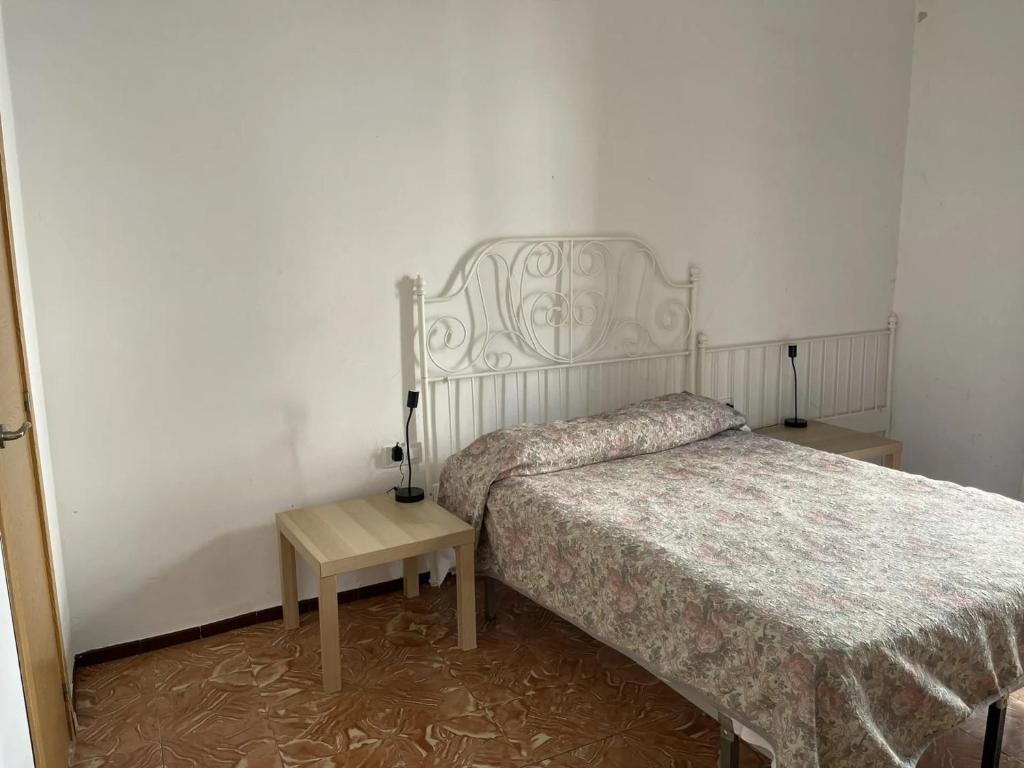 圣科洛马·德法尔琼方达酒店的一间卧室配有一张床和床头柜,配有四柱床和四柱床。