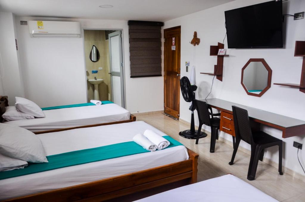 基布多Hotel Shaira 2的酒店客房配有两张床和一张书桌