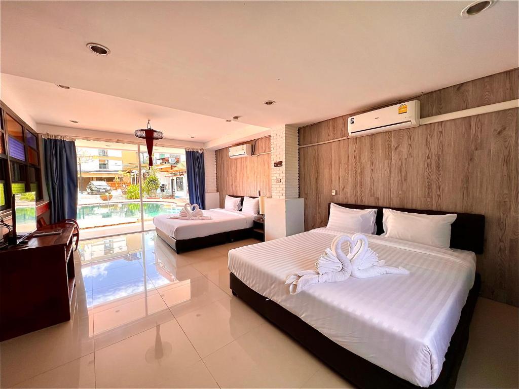 芭东海滩Baankasemsuk Resort 般咔 深宿的一间卧室配有两张床和白色毛巾。